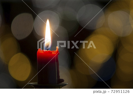Burning candle on black background with bokeh. Christian christmas concept.. 72951126