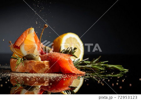 Sandwich with trout fillet, lemon slice, capers and rosemary sprinkle with pepper. Sandwich with trout fillet, lemon slice, capers and rosemary sprinkle with pepper. 72953123