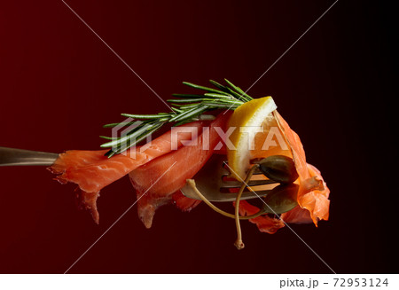 Trout fillets, lemon slice, capers and rosemary. 72953124