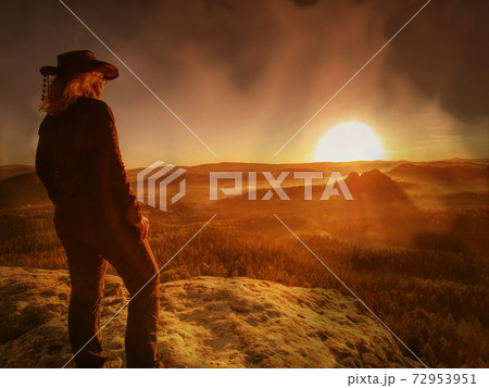 Carefree happy woman in black shirt and cowgirl hat enjoying nature view Carefree happy woman in black shirt and cowgirl hat enjoying nature view 72953951