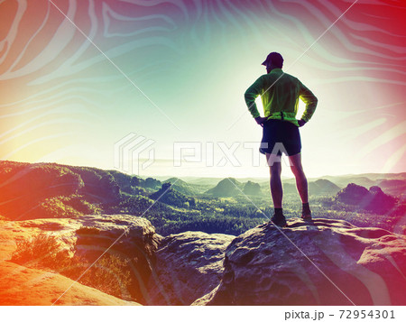 Silhouette of young sport man outdoors watching color sunset 72954301