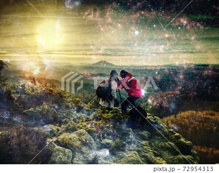 Rear view of couple photographers standing together with cameras and tripod 72954313