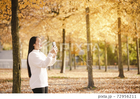 Asian beautiful woman is travel for holiday in the winter of Europe and view autumn leaves of big tree in Lausanne city at Switzerland,Vintage style and copy space. Asian beautiful woman is travel for holiday in the winter of Europe and view autumn leaves of big tree in Lausanne city at Switzerland,Vintage style and copy space. 72956211