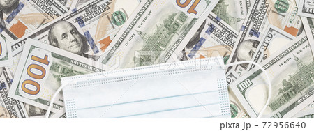 Protective face mask over hundred dollar bills. Coronavirus costs ppe business Protective face mask over hundred dollar bills. Coronavirus costs ppe business 72956640