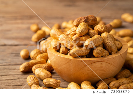 Sand roasted nuts in wooden bowl on wood plate background 72958379