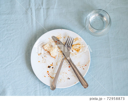 dirty plate after eating on the dining table 72958873