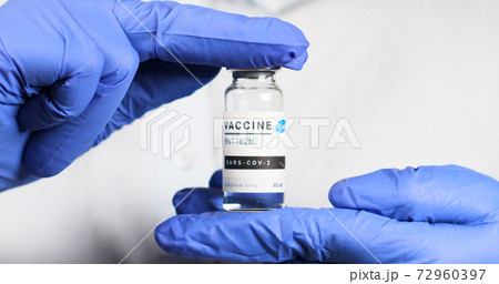 Odessa, Ukraine - December 9, 2020: Scientist or doctor in rubber gloves holds new BNT162b2 vaccine for injection of human volunteers against Sars-cov-2, coronavirus or covid-19. Odessa, Ukraine - December 9, 2020: Scientist or doctor in rubber gloves holds new BNT162b2 vaccine for injection of human volunteers against Sars-cov-2, coronavirus or covid-19. 72960397