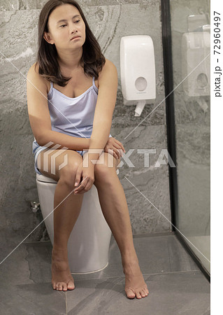 Closeup woman sitting on toilet in the morning with depressed feeling, selective focus Closeup woman sitting on toilet in the morning with depressed feeling, selective focus 72960497