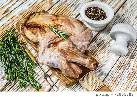 Oven Baked whole lamb shoulder on a cutting board. White wooden background. Top view Oven Baked whole lamb shoulder on a cutting board. White wooden background. Top view 72961585