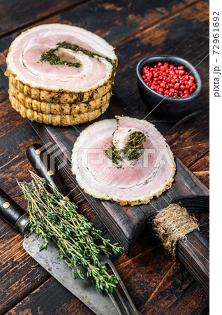 Sliced Italian pancetta on a cutting board. Dark Wooden background. Top view Sliced Italian pancetta on a cutting board. Dark Wooden background. Top view 72961692