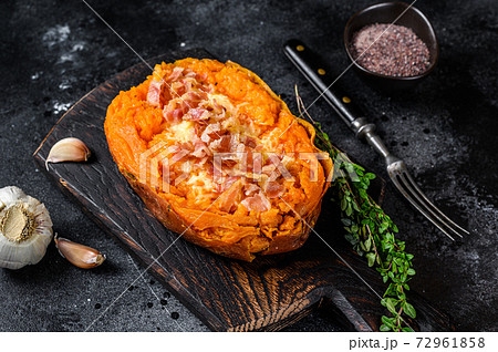 Baked sweet potato yam stuffed with ground beef and cheese. Black background. Top view 72961858