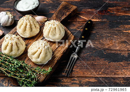 Traditional manti dumplings steamed with mince meat. Dark Wooden background. Top view. Copy space Traditional manti dumplings steamed with mince meat. Dark Wooden background. Top view. Copy space 72961965