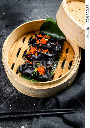 Black Dim sum dumplings in bamboo steamer. Asian cuisine. Black background. Top view Black Dim sum dumplings in bamboo steamer. Asian cuisine. Black background. Top view 72962288