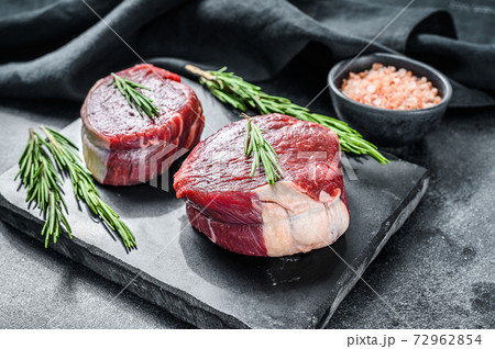 Raw steak Tenderloin fillet on a stone board. Black background. Top view Raw steak Tenderloin fillet on a stone board. Black background. Top view 72962854
