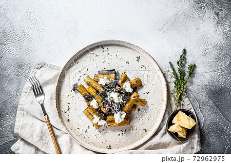 Pasta tortiglioni with black truffle, white mushroom, Cream Sauce and ricotta cheese. Gray background. Top view. Space for text Pasta tortiglioni with black truffle, white mushroom, Cream Sauce and ricotta cheese. Gray background. Top view. Space for text 72962975