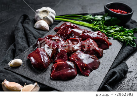 Raw Turkey liver on a stone Board. Black background. Top view 72962992