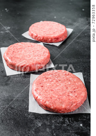 Raw Burger patties, ground beef meat. Black background. Top view 72963358