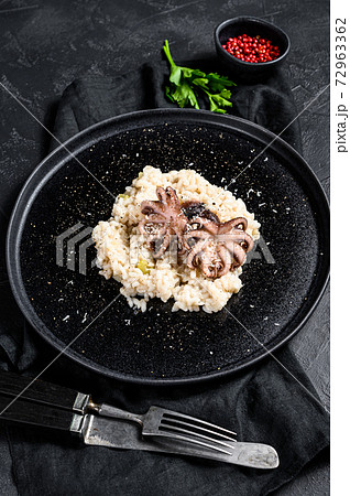 Italian homemade Risotto with octopus and mushrooms, parsley and spices. Black background. Top view 72963362