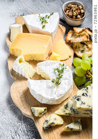Cheese Board with French Camembert, brie, Parmesan and blue cheese, grapes and walnuts. White background. Top view Cheese Board with French Camembert, brie, Parmesan and blue cheese, grapes and walnuts. White background. Top view 72963961