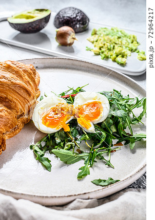 Breakfast, brunch with avacado, arugula, croissant and egg. Gray background. Top view 72964217