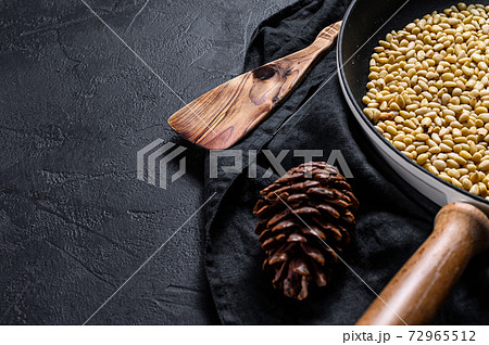 Roasted pine nuts in a frying pan. Black Roasted pine nuts in a frying pan. Black 72965512