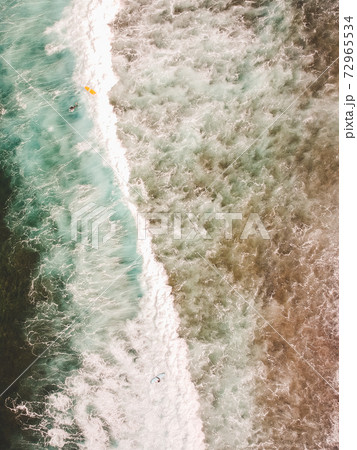 Aerial view of surfers in the waves of the Aerial view of surfers in the waves of the 72965534
