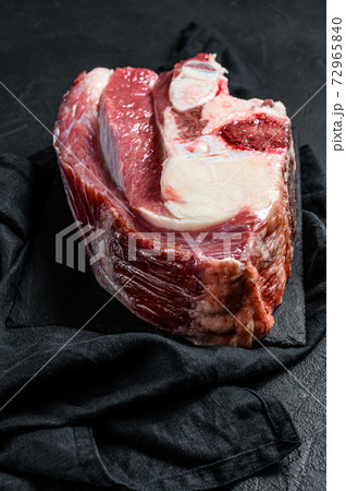 Raw beef shank on black background. Top view 72965840