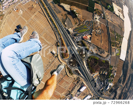 Air view of people couple doing paraglyde adrenaline experience - pilot and passenger paraglyiding over the city - outdoor excursion leisure activity 72966268