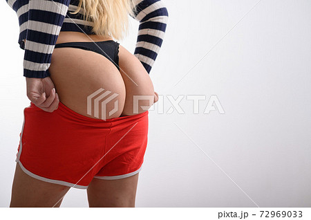 A blonde with long hair puts on sports red - Stock Photo [79115310] -  PIXTA