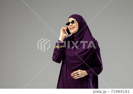 Beautiful arab woman posing in stylish hijab isolated on studio background. Fashion concept Beautiful arab woman posing in stylish hijab isolated on studio background. Fashion concept 72969181