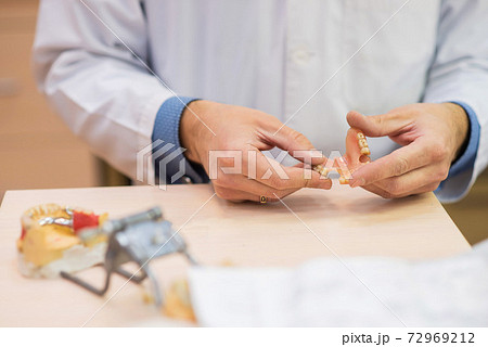 A dental technician makes partial dentures. The production of false teeth or dental bridges. Close-up. A dental technician makes partial dentures. The production of false teeth or dental bridges. Close-up. 72969212