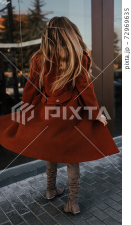 woman in autumn clothes walks on street background shop windows woman in autumn clothes walks on street background shop windows 72969635