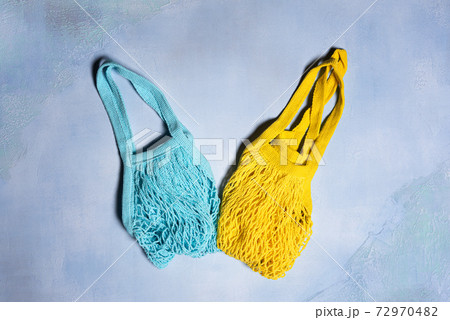 Blue and yellow mesh bags on blue concrete Blue and yellow mesh bags on blue concrete 72970482
