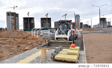 Bobcat skid-steer loader for loading and unloading works on city streets.  72970933