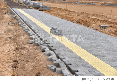 Laying paving slabs at construction site.  72970936