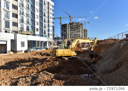 Excavator on earthworks for laying heating pipes and stormwater in trench. Excavator on earthworks for laying heating pipes and stormwater in trench. 72971266