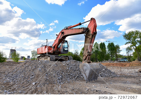 Excavator work at landfill with concrete demolition waste. Excavator work at landfill with concrete demolition waste. 72972067