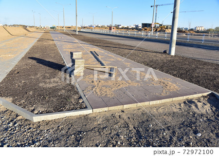 Laying paving slabs and borders at construction site. Laying paving slabs and borders at construction site. 72972100