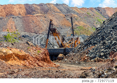 Big excavator working in iron ore quarry. Mining industry Big excavator working in iron ore quarry. Mining industry 72977119