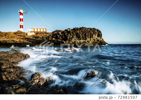 Beautiful scenic landscape with classic lighthouse on the coast and blue ocen and sky in background - concept of travel and vacation for tourism - wave and rocks Beautiful scenic landscape with classic lighthouse on the coast and blue ocen and sky in background - concept of travel and vacation for tourism - wave and rocks 72981507
