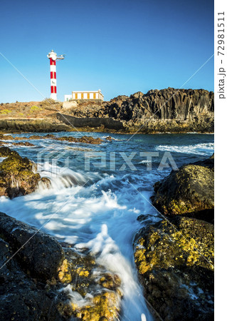 Beautiful scenic landscape with classic lighthouse on the coast and blue ocen and sky in background - concept of travel and vacation for tourism - wave and rocks 72981511