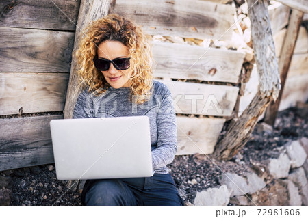 Attractive people adult blonde woman use laptop. computer outdoor -  connected everywhere and digital nomad lifestyle - concept of workers in outdoors no office 72981606