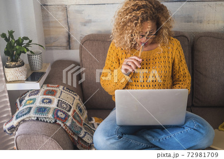 People at work at home - beautiful curly adult woman working on the sofa with modern laptop computer - freelance free from office lifestyle - independent worker- job search People at work at home - beautiful curly adult woman working on the sofa with modern laptop computer - freelance free from office lifestyle - independent worker- job search 72981709