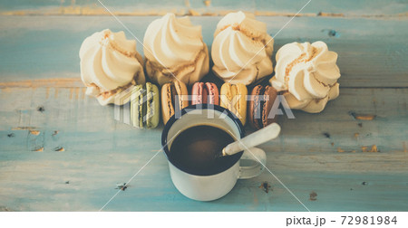Vintage style sweet breakfast concept with coffee and macarones biscuits little cakes on a blue wooden background viewed from above - food and sweet biscuits - sugar power lifestyle Vintage style sweet breakfast concept with coffee and macarones biscuits little cakes on a blue wooden background viewed from above - food and sweet biscuits - sugar power lifestyle 72981984