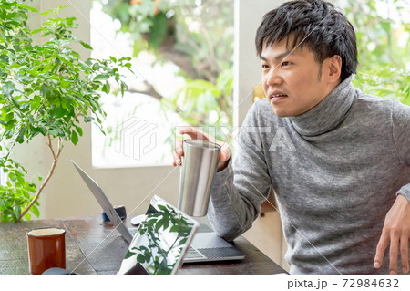 緑あふれるオフィスで談笑して一息いれている男性 緑あふれるオフィスで談笑して一息いれている男性 72984632