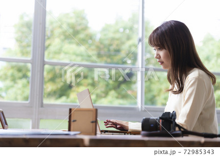窓際でパソコン作業をする20代女性 窓際でパソコン作業をする20代女性 72985343
