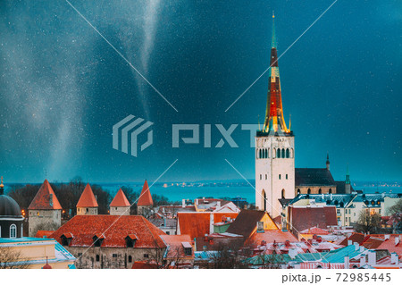 Tallinn, Estonia. Night Starry Sky Above Traditional Old Architecture Skyline In Old Town. Church Of St. Olaf Or Olav In Winter Evening Night. Famous Landmark. Altered Sky With Stars. UNESCO Heritage 72985445