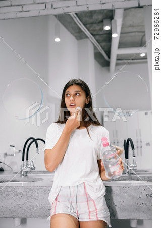 Painting of a beautiful young woman with a cotton pad in the bathroom Painting of a beautiful young woman with a cotton pad in the bathroom 72986284