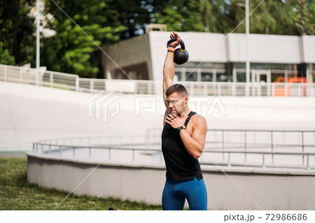 Sportive guy training with kettlebell. Strength and motivation. Sportive guy training with kettlebell. Strength and motivation. 72986686