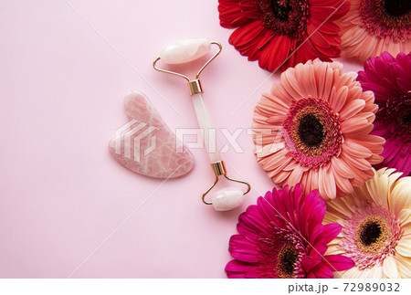 Jade face roller and gerbera flowers Jade face roller and gerbera flowers 72989032